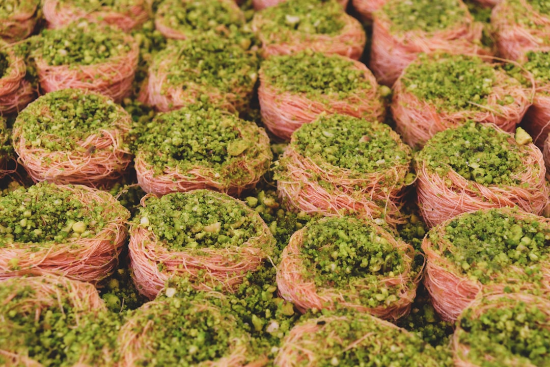 Grilled steak topped with bright green microgreen chimichurri sauce on white plate