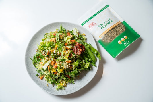 Colorful cold noodle salad topped with fresh microgreens and sesame seeds in white bowl