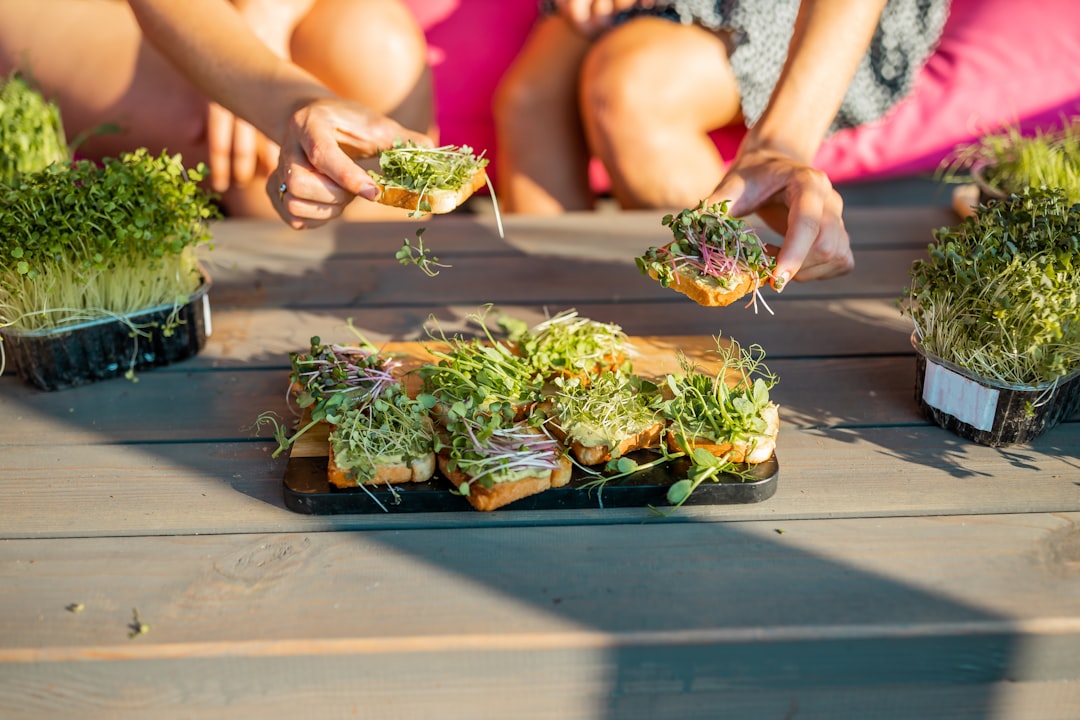 Pulled pork sliders topped with radish microgreen slaw on a wooden serving board