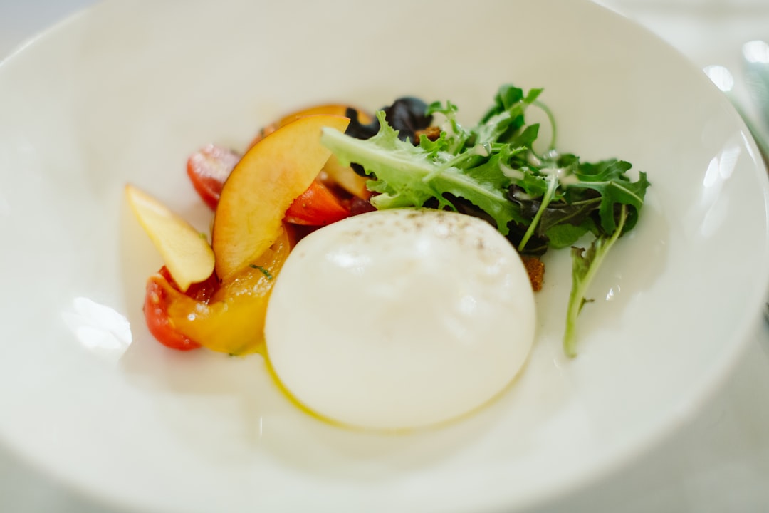 Microgreen peach caprese salad on a white platter with fresh mozzarella, sliced peaches, and basil microgreens