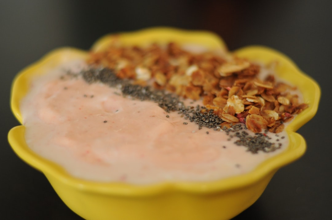 Purple acai bowl topped with colorful microgreens and granola in a white bowl
